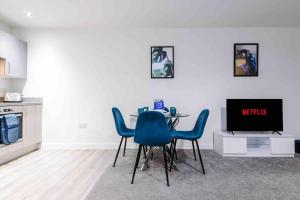 uma sala de jantar com uma mesa e cadeiras azuis em Luxury 2BR Apartment in Central *FREE PARKING* em Manchester