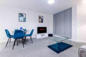 uma sala de estar com uma mesa e cadeiras e uma televisão em Luxury 2BR Apartment in Central *FREE PARKING* em Manchester