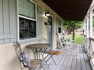 a porch with a table and chairs on a house at The Alexander at Creek Road in Dripping Springs