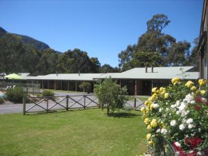 a building with a bunch of flowers in front of it at Halls Gap Log Cabins in Halls Gap
