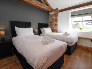a bedroom with two beds and a window at Molly's Cottage in Malton