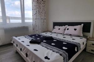 a bedroom with a bed with a black and white comforter at Ultracentral Residence 6 in Ploieşti