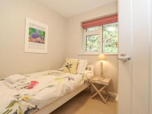 een kleine slaapkamer met een bed en een raam bij T'whit T'woo in Windermere