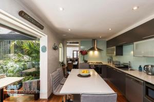 a kitchen with a large white table and chairs at 3 Bedroom House With Large Courtyard & City Views in Sydney