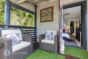 雪梨的住宿－3 Bedroom House With Large Courtyard & City Views，门廊设有2把椅子和1张床