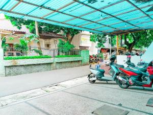 雅加達的住宿－Wisma Juanda Powered by Cocotel，停在街道边的两辆摩托车