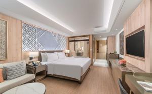 Henann Premier Coast Resort في بنغلاو: غرفة نوم مع سرير وغرفة معيشة