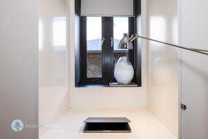 a window with a vase sitting on a table at Darlinghurst Apt W A C Balcony Only A Walk To CBD in Sydney +25 photos
