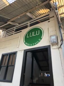 un edificio con un cartel en el costado en Lulu Mocktails en San Juan del Sur