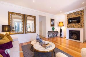 uma sala de estar com um sofá e uma lareira em Annandale Sydney 2 Storey Cottage + Courtyard em Sydney