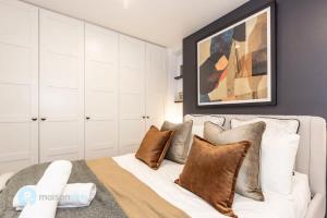 um quarto com uma cama branca e almofadas castanhas em Annandale Sydney 2 Storey Cottage + Courtyard em Sydney