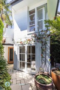 uma casa com uma porta com flores num pátio em Annandale Sydney 2 Storey Cottage + Courtyard em Sydney