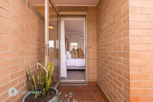 a brick wall with a bedroom in the background at Newly listed 1 Bdrm Apt Parking Great Location in Sydney