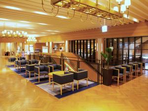 a lobby with a waiting area with chairs and tables at Iwaki Washington Hotel in Iwaki