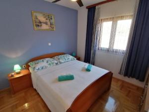 ein Schlafzimmer mit einem Bett mit zwei grünen Tassen darauf in der Unterkunft Ferienhaus für 7 Personen und 1 Kind in Jasenice, Dalmatien Norddalmatien in Jasenice