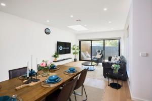 comedor y sala de estar con mesa y sillas en 5 Bedroom 5 Bathroom Townhouse with Aircon en Melbourne