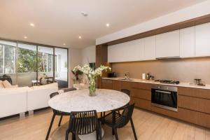 Una cocina y un comedor con mesa y sillas. en Luxurious Spacious OneBed Apt close to Bondi Beach, en Sídney