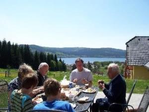 un grupo de personas sentadas alrededor de una mesa comiendo en Ferienhaus für 10 Personen in Slupecna, Böhen Moldau, en Lipno nad Vltavou