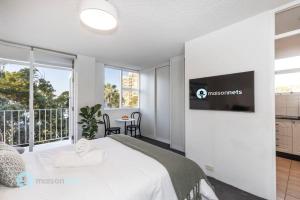 une chambre avec un lit et une télévision sur un mur dans l'établissement Studio Apt With Parking Balcony & Water Views, à Sydney