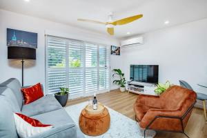 a living room with a couch and a tv at 1 Bedroom Gem with Aircon Stroll to Beach in Gold Coast