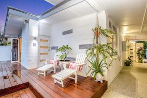 Gold Coast-Miami Mid-Century Beach Home With Pool في غولد كوست: غرفة معيشة بها كرسيين بيض ونباتات