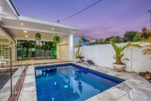 Gold Coast-Miami Mid-Century Beach Home With Pool في غولد كوست: مسبح في الحديقة الخلفية للمنزل