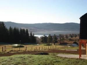 um celeiro e um campo com vista para um lago em Ferienhaus für 10 Personen in Lipno nad Vltavou, Böhen Moldau em Lipno nad Vltavou