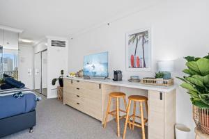 sala de estar con escritorio y 2 taburetes en Mantra View Studio Surfers Paradise Walk To Beach, en Gold Coast
