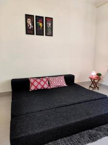 科钦Flat in Kochi (302)的墙上挂着照片的黑色沙发