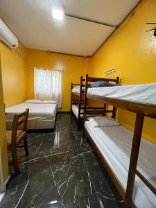 Cette chambre dispose de 3 lits superposés et d'un mur jaune. dans l'établissement Hotel Music and Sports, à São Paulo