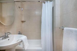 a bathroom with a sink and a tub and a shower at Luxury Elv Bldg 24H DM Gym Studio walk from C park in New York