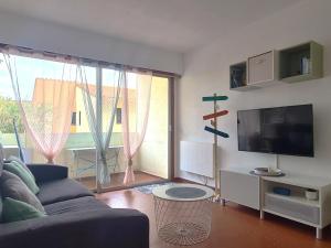 a living room with a blue couch and a large window at Appartement T2 à Collioure avec Terrasse et Parking Privé, à 300m de la Plage - FR-1-309-385 in Collioure