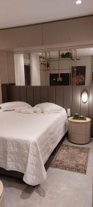 a bedroom with a large white bed in it at Apartamento Studio Hub Smart in Criciúma