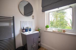 baño con lavabo y ventana en Aqua nest Eastbourne en Eastbourne