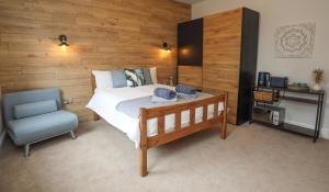 a bedroom with a bed and a blue chair at Aqua nest Eastbourne in Eastbourne