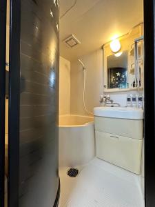 een badkamer met een bad, een wastafel en een douche bij ラ・パルフェド・札幌607/La Parfait Sapporo　607 in Kita-rokujō