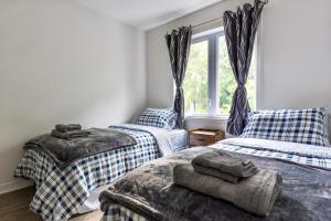 a bedroom with two twin beds and a window at Appartment 2BR 4 beds AC wi-Fi Smart TV FreeParking in Laval