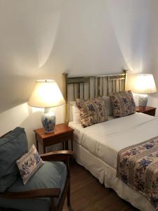 um quarto com 2 camas, um candeeiro e uma cadeira em Gran Texier Hotel Casino em Concepción del Uruguay