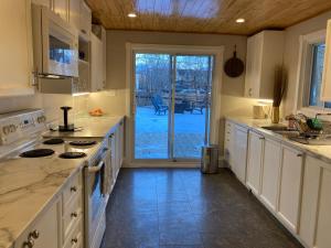 a kitchen with white cabinets and a door to a patio at Lovely Leslieville, exploring nature in the city in Toronto