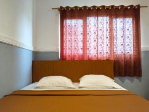 雅加達的住宿－Wisma Juanda Powered by Cocotel，窗户前的一张带两个枕头的床
