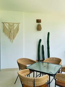 a dining room with a table and chairs and a cactus at Estudio acogedor con vista al mar in Nuevo Vallarta