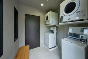 a small kitchen with a refrigerator and a microwave at LUXE TECH VILLA Ashitoku - Vacation STAY 10822v in Akaoki