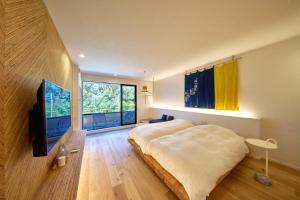 sypialnia z dużym łóżkiem i telewizorem w obiekcie LUXE TECH VILLA Ashitoku - Vacation STAY 10822v w mieście Akaoki