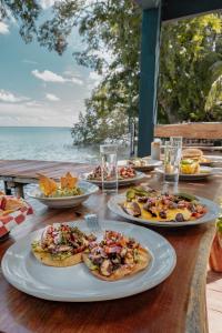 una mesa de madera con platos de comida. en B 7 BLUE BACALAR, en Bacalar