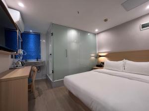 une chambre d'hôtel avec un grand lit et une cuisine dans l'établissement Pod Hotel - Guangzhou Luoxi Subway Station Canton Tower, à Canton