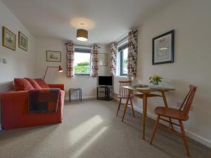 a living room with a red couch and a table at Lillemor in Okehampton
