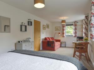 a bedroom with a bed and a chair and a table at Lillemor in Okehampton