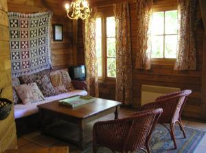 uma sala de estar com um sofá e uma mesa em Residences Du Golf Des Roucous em Sauveterre