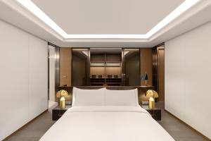 - une chambre avec un lit blanc et un bureau dans l'établissement Wyndham Grand Busan, à Busan