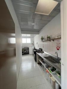 eine große Küche mit einer Spüle und einer Theke in der Unterkunft Casa Ambrosía in Calarcá